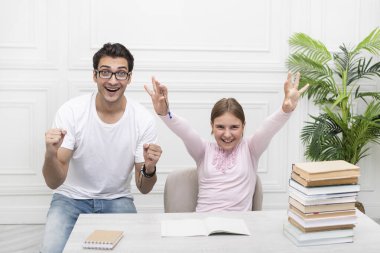 Neşeli baba ve kızı ödevlerini bitirdikten sonra harika hissediyorlar. Ebeveyn ve çocuk birlikte okuyorlar. Okul hazırlığı ve sınav konsepti