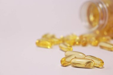 fish oil capsules with omega 3, blurred bottle in background