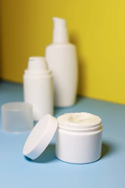 mock up of white jar of cream on a yellow background. Ready place for the label, copy space