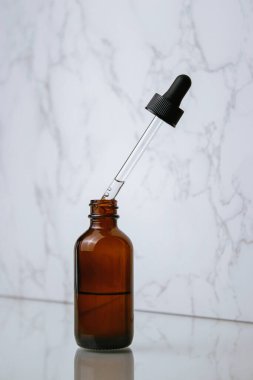 glass bottle of facial oil on white background  with copy space