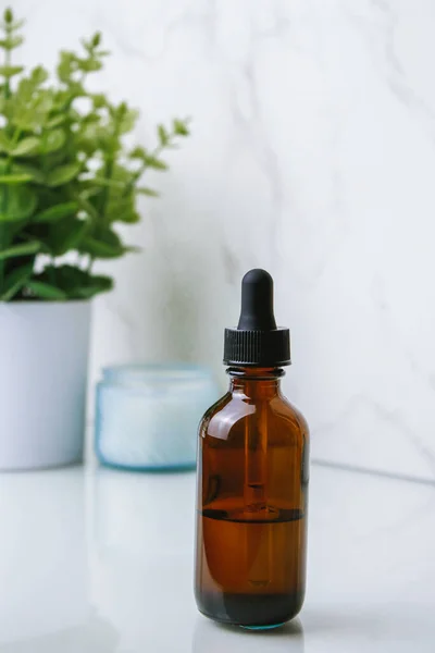 glass bottle of facial oil on white background