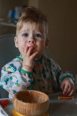 baby eating by himself learning through the Baby-led Weaning method, exploring the food