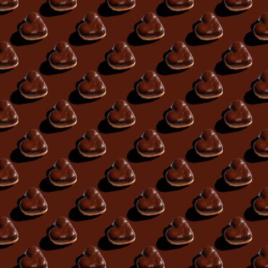 pattern of chocolate heart shaped donuts on a brown background