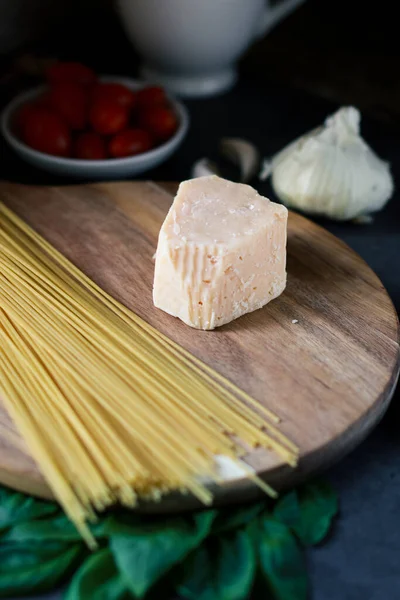Close Spagetti Parmesan Cheese Wooden Board Blurred Background Tomatoes Garlic — 스톡 사진