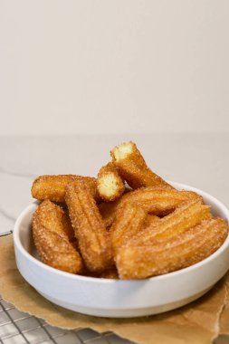 Churros 'u beyaz kasede şekerli yakın çekim, üst manzara. Yüksek kalite fotoğraf