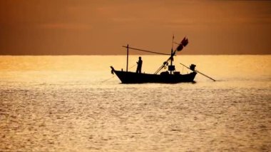 Balıkçı ve teknesi gün batımında
