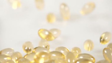 Hap kapsülleri beyaz arkaplan üzerine düşüyor, yavaş çekim