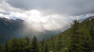 Timelapse of sun rays piercing clouds over mountains