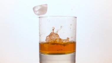 Ice cubes falling in a glass of whiskey