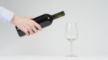 Hand pouring a glass of red wine.