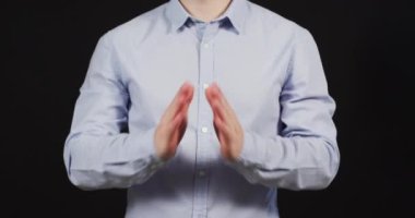 The praying gesture of a man in blue shirt