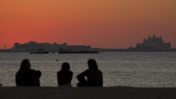 Three People Admiring Evening Sky Beach Royaltyfri Stockvideo