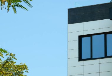 Facade and window of a new house against the sky. New building, house corner and roof edge