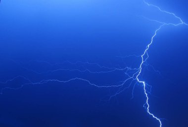 Bright lightning on the blue sky at night. Background image with lightning. Night thunderstorm