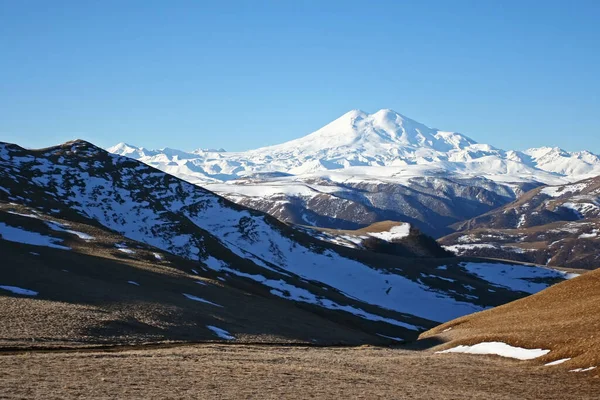 Elbrus is a high mountain. Dormant volcano. Mountain covered with snow on blue sky background. Caucasus mountains. Slopes