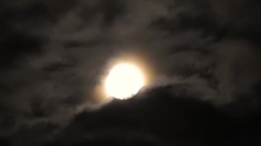 Moon in the clouds. Mystery of the night sky. Clouds are flying fast in front of the moon