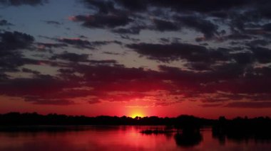 Sunset timelapse. Clouds fly over the river (lake). Evening landscape. Red sunset