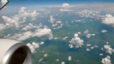 Airplane flight over the earth. Flight over cumulus clouds. View from the porthole during the day