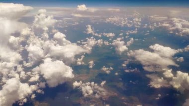 Airplane flight above the clouds. Cumulus clouds. View from the airplane window. Traveling by air