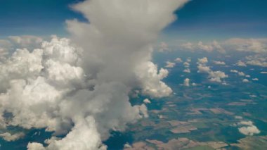 Flight in the sky above the earth on an airplane. Air travel with a view from the porthole on cumulus clouds. Timelapse
