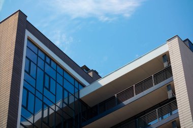 New modern building glass facade and balconies. Reflection of the sky in mirrored windows