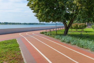 Bicycle path on a sunny day on the banks of the Dnieper River in the Kremenchuk city, Ukraine. White lines on the pedestrian sidewalk