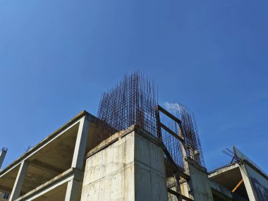 Unfinished building made of concrete and metal against the blue sky
