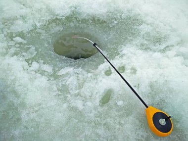 Buz balıkçılığı. Delik buzda ve oltaya yakın çekim. Gündüz ve gün ışığı