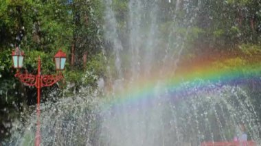 Güneşli bir günde fıskiyede gökkuşağı ve fıskiyeler. Ukrayna 'nın Horishni Plavni şehrindeki halk parkı.