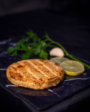 Soya soslu hamburger ve maydanozlu yulaf ezmesi, sarımsak, limon ve siyah bir arka plan.. 