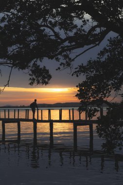 Mavi saatte gün batımını seyreden bir adam.