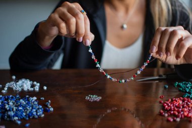 Female person showing handcrafted  necklace. Horizontal