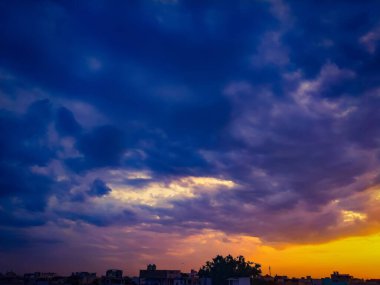 Dramatic sunset sky with clouds,  Beautiful landscape during sunset, sunset over dark silhouettes of city buildings