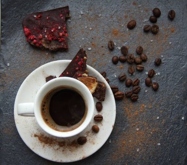 Koyu arkaplanda çikolata ve şeker olan kahve fincanı.