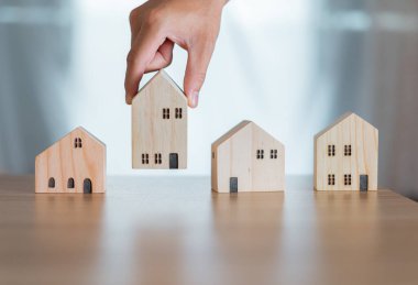 Masaya tahta bir ev koyan bir işadamı, uzun vadeli yatırım planlamak için en iyi evi seçerek gayrimenkul yatırımı yapar. Sermaye amca, para biriktiriyor. Kiralık mülk..