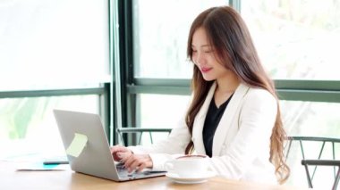 Asian business women wear suits are working in the office with laptop and morning stressed and working hard, analytics, planning, marketing finance, Assess the profit company, entrepreneur, startup