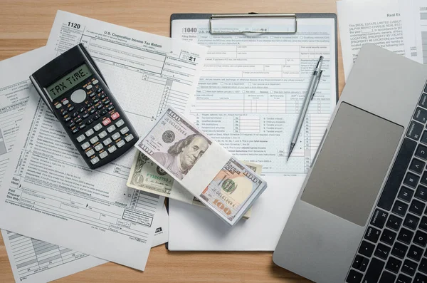 US Federal Income Tax Time filing forms, the Internal Revenue Service (IRS), pencils calculators and laptops are used to calculate pre-delivery taxes to prepare income statement reports personal.