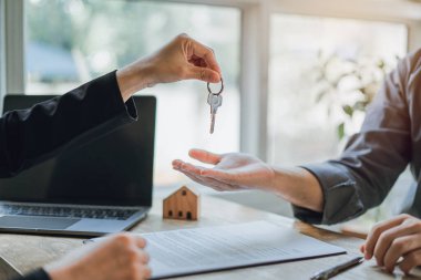 Emlakçı kadın ofisteki müşteriye ev anahtarları veriyor danışmanlık ve koşullar ve sözleşmeler imzalıyor yasal belgelerle ilgili sözleşmeler, müşteri memnuniyeti kavramını, taşınma evini.