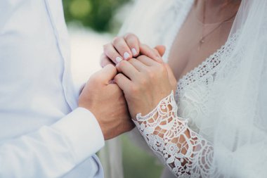 Gelin ve damat düğün gününde el ele tutuşuyorlar.