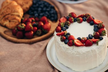 Böğürtlenli lezzetli pasta ve beyaz tabakta meyve