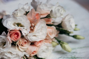 Beyaz arka planda güller olan alyanslar