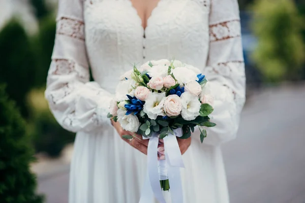 beautiful bride with flowers in the hands of the groom