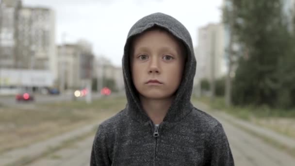 Хлопчик у чорному капюшоні надворі — стокове відео