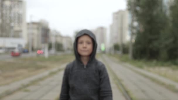 Junge mit schwarzer Kapuze draußen — Stockvideo