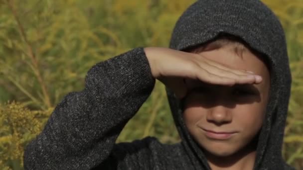Rapaz bonito em um capuz cinza ao ar livre — Vídeo de Stock
