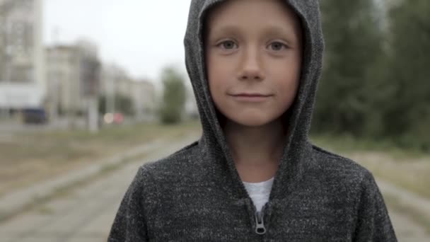 Хлопчик у чорному капюшоні надворі — стокове відео