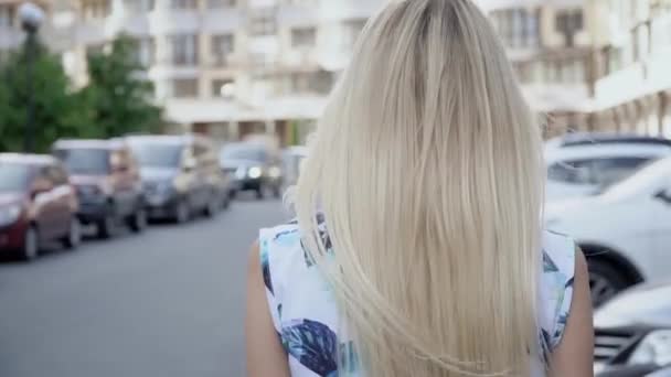 Blond im Sommeranzug posiert auf dem Parkplatz. Kameraverkabelung. Frauenlauf — Stockvideo