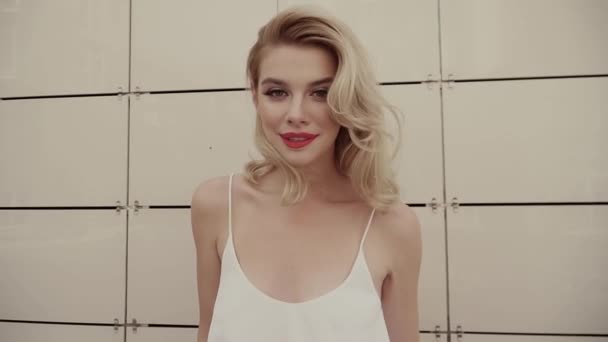 Portret van een mooie sexy lachende gelukkig meisje met grote volle lippen met blond haar — Stockvideo