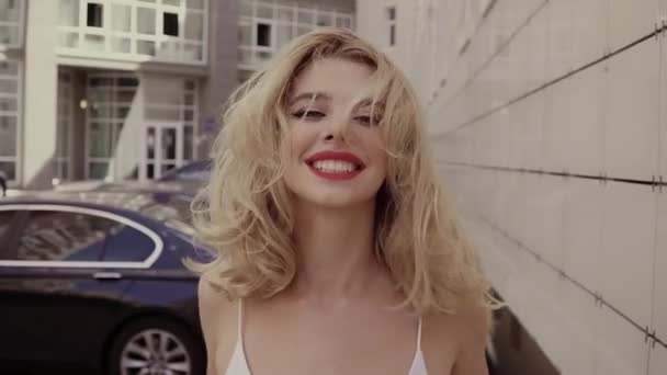Porträt eines schönen sexy lächelnden glücklichen Mädchens mit großen vollen Lippen und blonden Haaren — Stockvideo