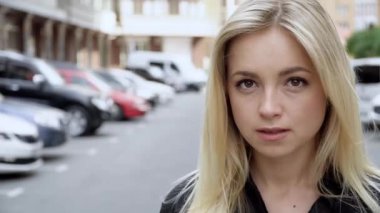 Kamera genç ve çekici bir kızı izliyor. Kadınlar yürür